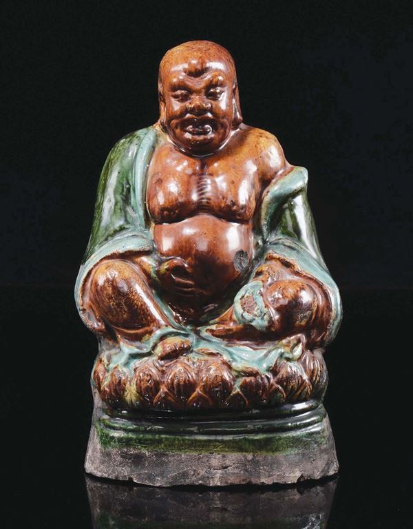 A glazed stoneware figure of Budai on lotus flower, China, Ming Dynasty, 17th century