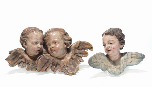 Tre testine di angioletti in legno intagliato e laccato, XVIII secolo