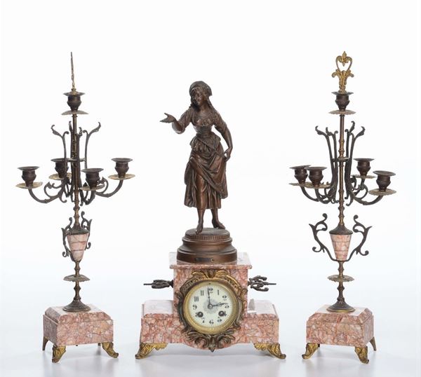 Trittico da camino composto da orologio  sormontato da figura femminile e candelabri a cinque luci, basi in marmo rosso