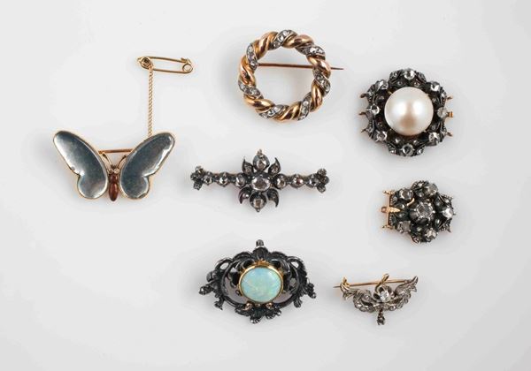 Lot composed by five gold,silver, gem-set and paste brooches and two clasps