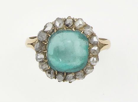 An emerald cabochon-cut and diamond cluster ring