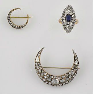 A group including a marquise-shaped sapphire ring and a couple of half moon brooches