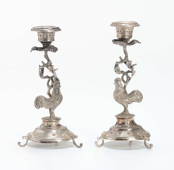 Coppia di candelieri in argento sbalzato, XX secolo