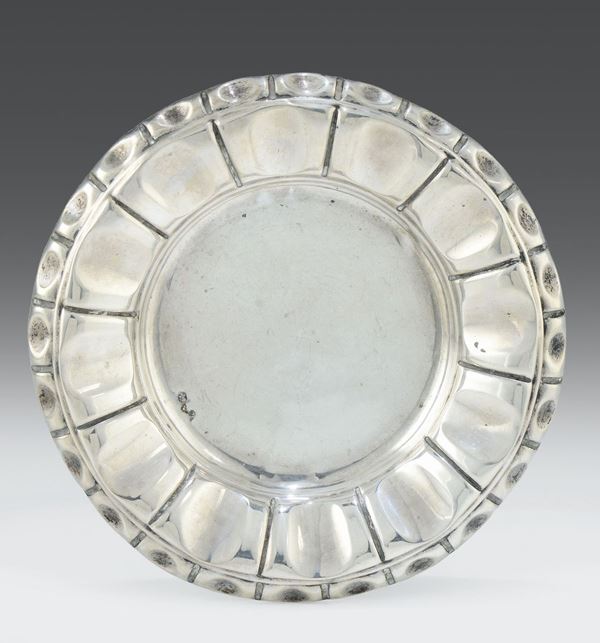 Piccolo piatto in argento sbalzato con bordo baccellato, Genova XIX secolo, punzone della croce Mauriziana e delfino in uso dal 1825 al 1872