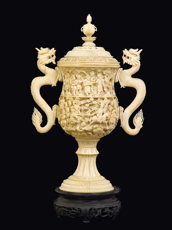 A carved ivory cup and cover with dragon-handles and figures in relief, China, Qing Dynasty, 19th century