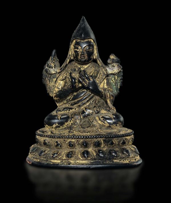 A cold gilt bronze figure of Tsong khapa on a double lotus flower, Tibet, 17th century