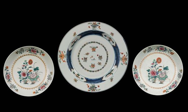 Grande piatto e coppia di piattini in porcellana a smalti policromi con decoro floreale, Cina, Dinastia Qing, XVIII secolo