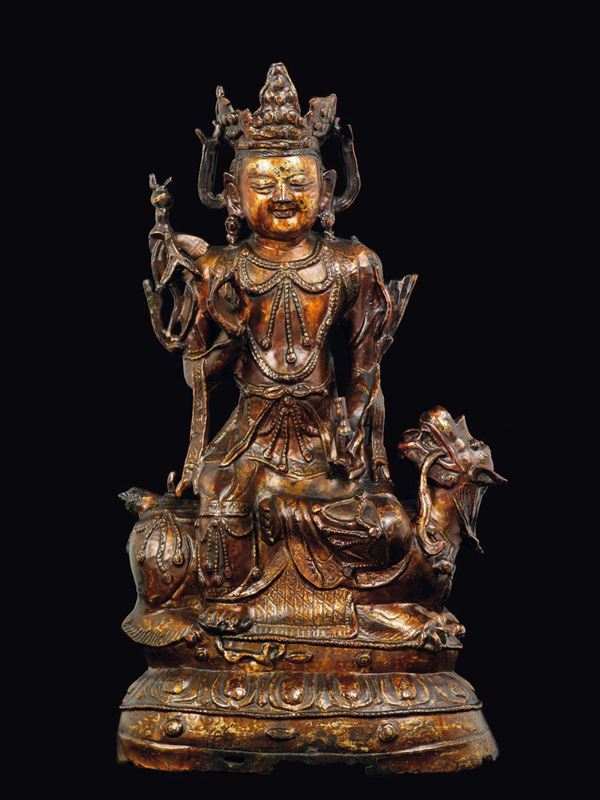 A cold gilt bronze figure of Simhanada-Avalokitesvara seated on Pho dog, China, Ming Dynasty, 16th century