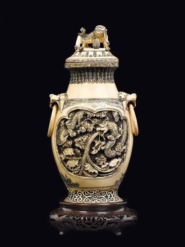 A carved ivory vase and cover with ring-handles and dragons within reserves, China, Canton, Qing Dynasty, 19th century