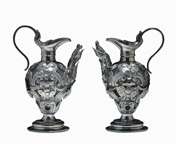 Coppia di ampolle da messa in vetro rivestito in argento sbalzato e cesellato. Italia centrale, Roma (?) XVII-XVIII secolo