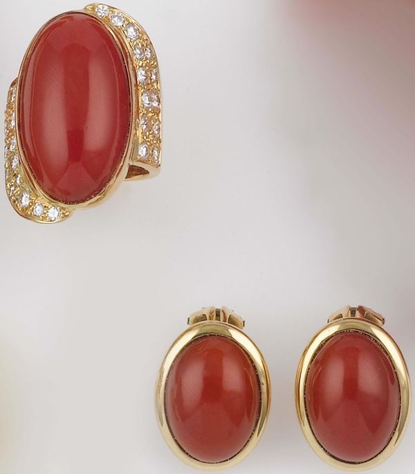 A pair of gold and coral earrings and a diamond and coral ring