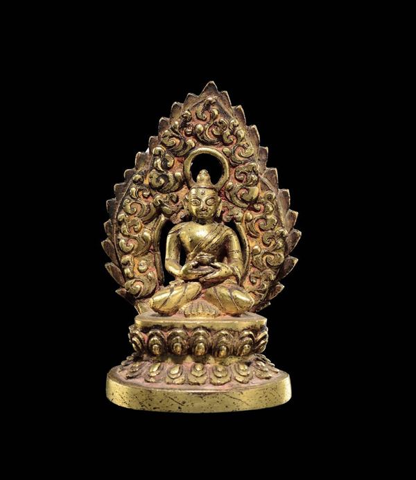 A small gilt bronze figure of Sakyamuni with aura on a double lotus flower, China, Ming Dynasty, 15th century