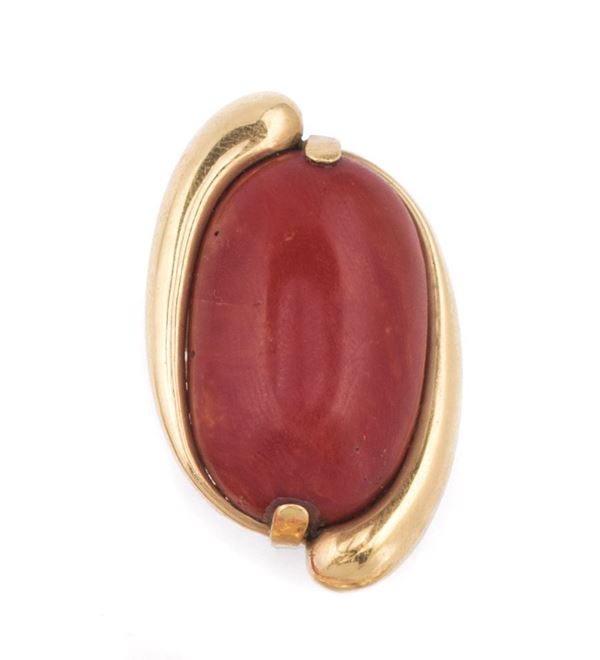 A coral cabochon and gold ring