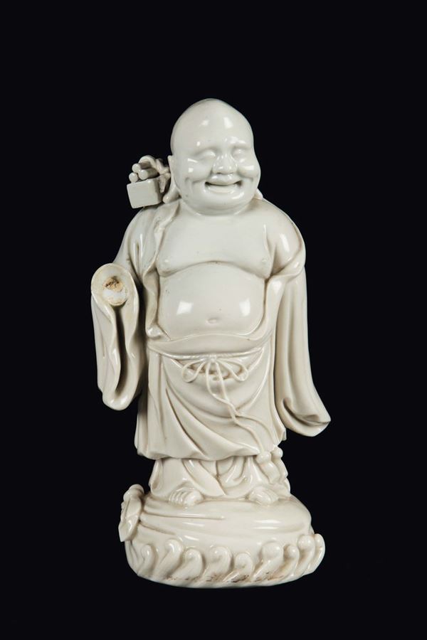 Figura di Budai in porcellana Blanc de Chine con scatola sulle spalle, Cina, Dinastia Qing, fine XVII secolo