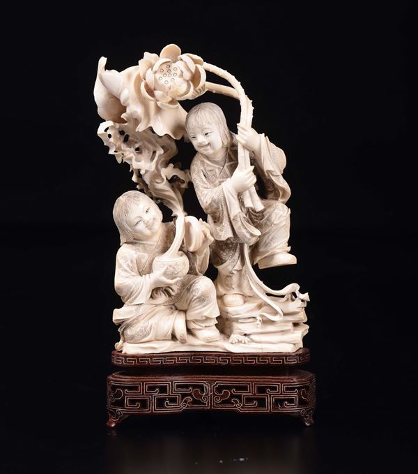 A carved ivory children with flowers group, China, early 20th century