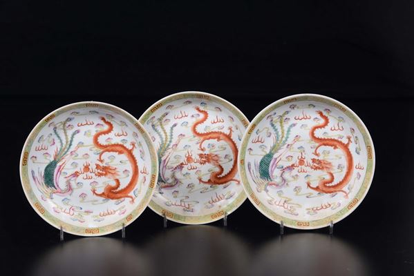 Tre piatti in porcellana a smalti policromi con decoro centrale di fenice e dragone, Cina, Dinastia Qing, XIX secolo