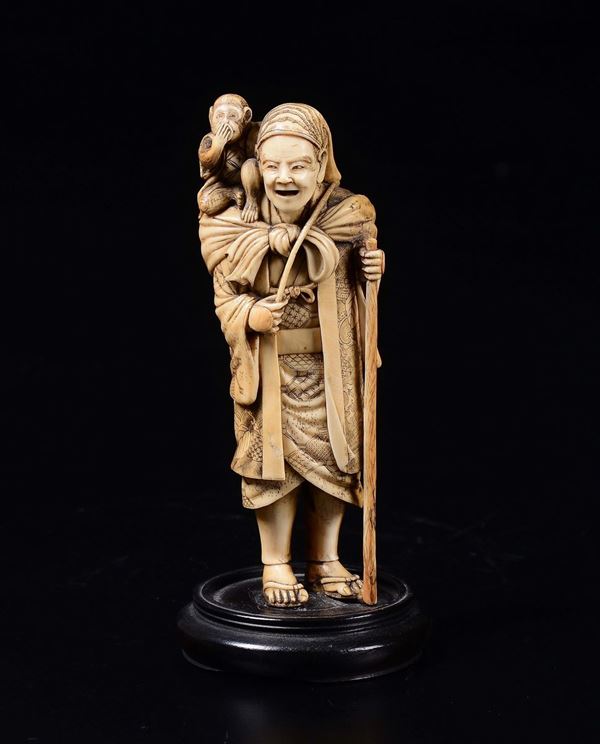 A carved ivory figure of wayfarer with monkey, Japan, early 20th century
