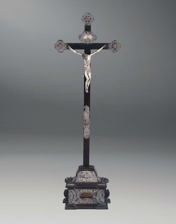 A table crucifix in embossed silver, ebonised wood and coloured stones. Italian art from the 18th century.