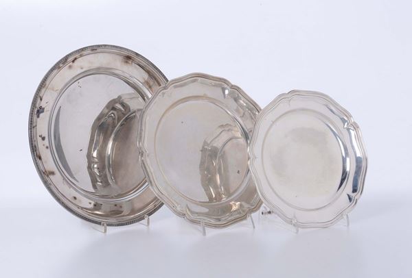 Coppia di piatti in argento con bordo sagomato e piatto tondo in argento con bordo a palmette