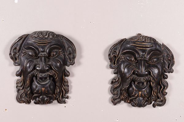Coppia di mascheroni in legno intagliato e laccato, XVII secolo