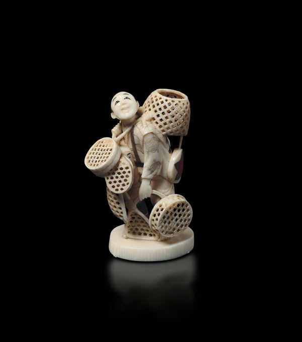 A carved ivory figure of peasant with wicker baskets, Japan, early 20th century