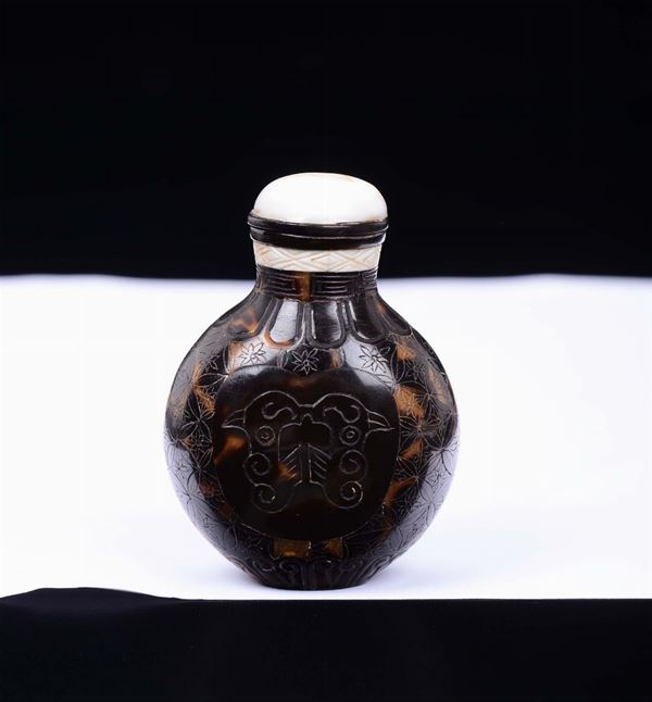 Snuff bottle in tartaruga con incise teste di uccelli e fenici di gusto arcaico con tappo in madreperla, Cina, Dinastia Qing, XIX secolo