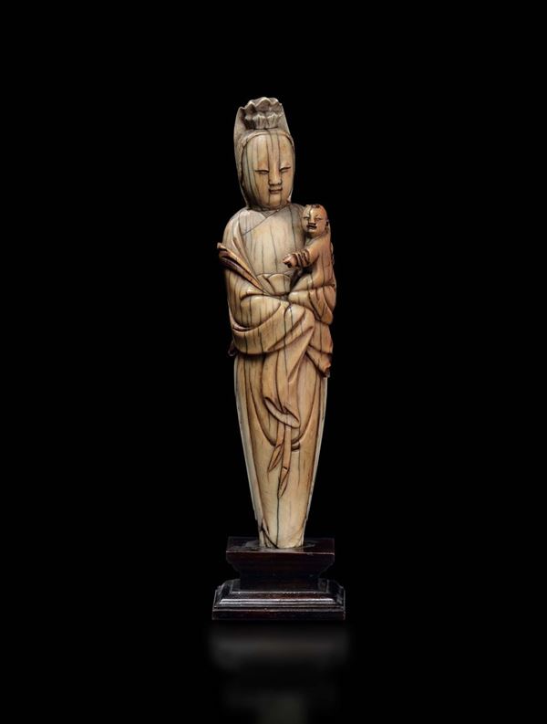 A carved ivory figure of Guanyin with child, China, Ming Dynasty, 16th century