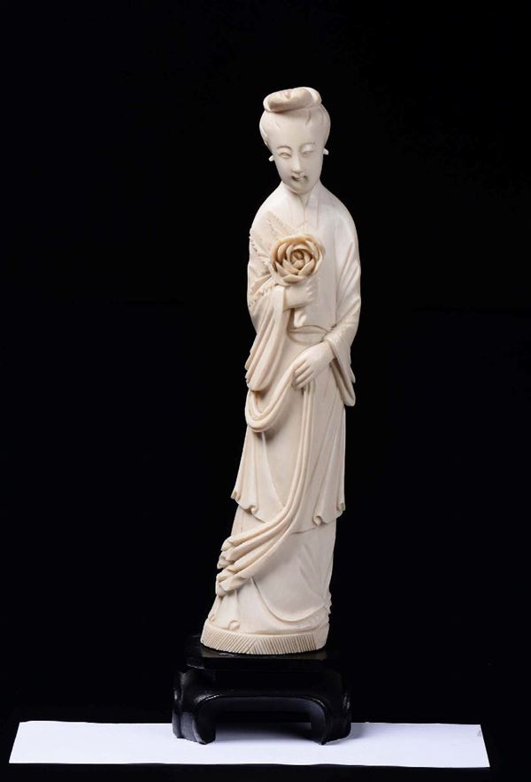 A carved ivory figure of Guanyin with flower, China, early 20th century