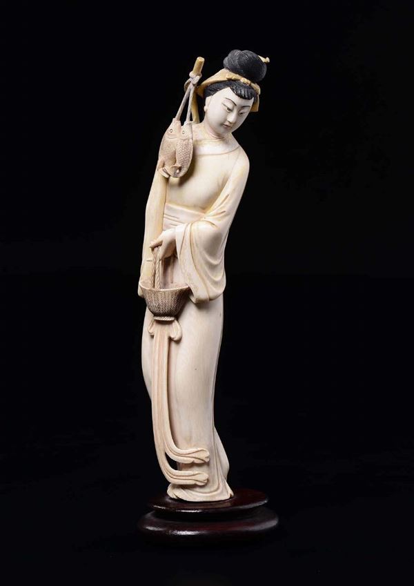 A carved ivory figure of Guanyin with fish, China, Republic, early 20th century