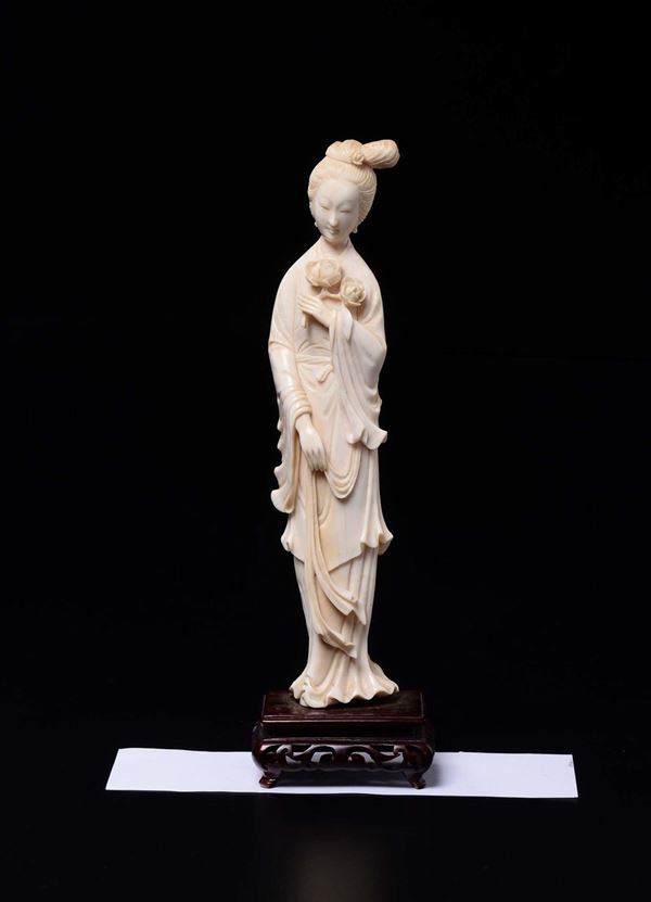 A carved ivory figure of Guanyin with flower, China, early 20th century