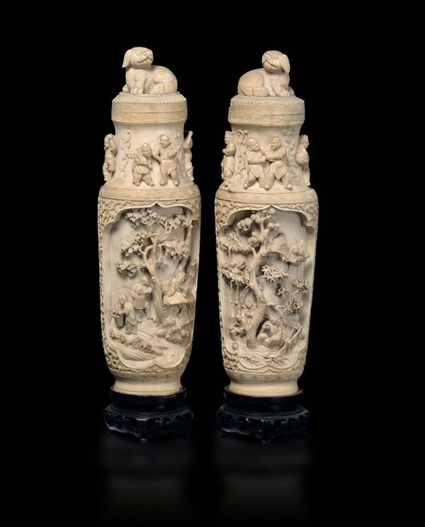A pair of carved ivory vases and cover with common life scenes and children in relief, China, Qing Dynasty, 19th century