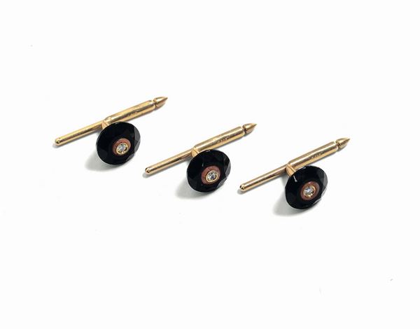 A pair of coral, onyx and diamond studs set in gold
