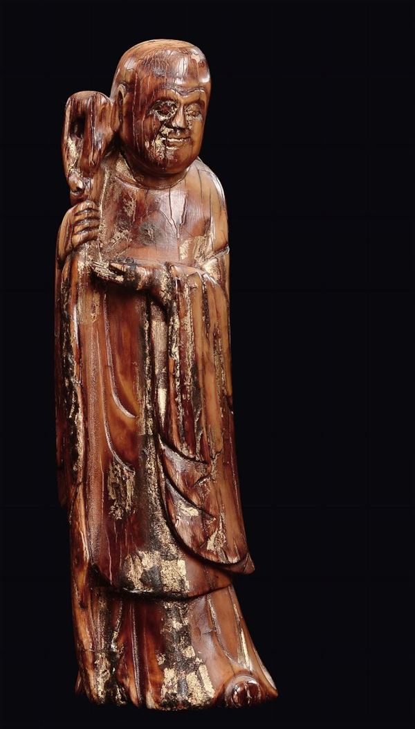 A semi-gilt lacquered ivory wise man with stick figure, China, Ming Dynasty, 17th century