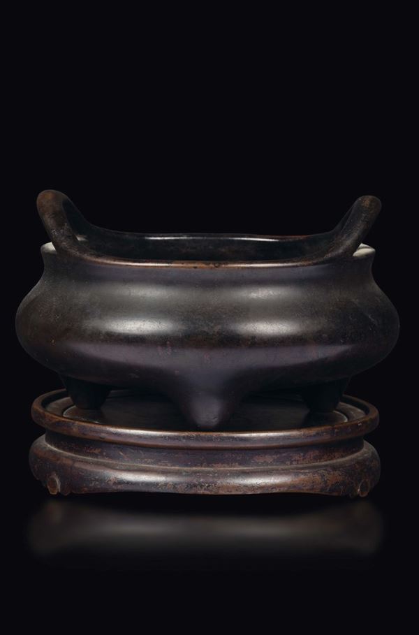 A bronze tripod censer with handles on a bronze stand, China, Ming Dynasty, late 17th century