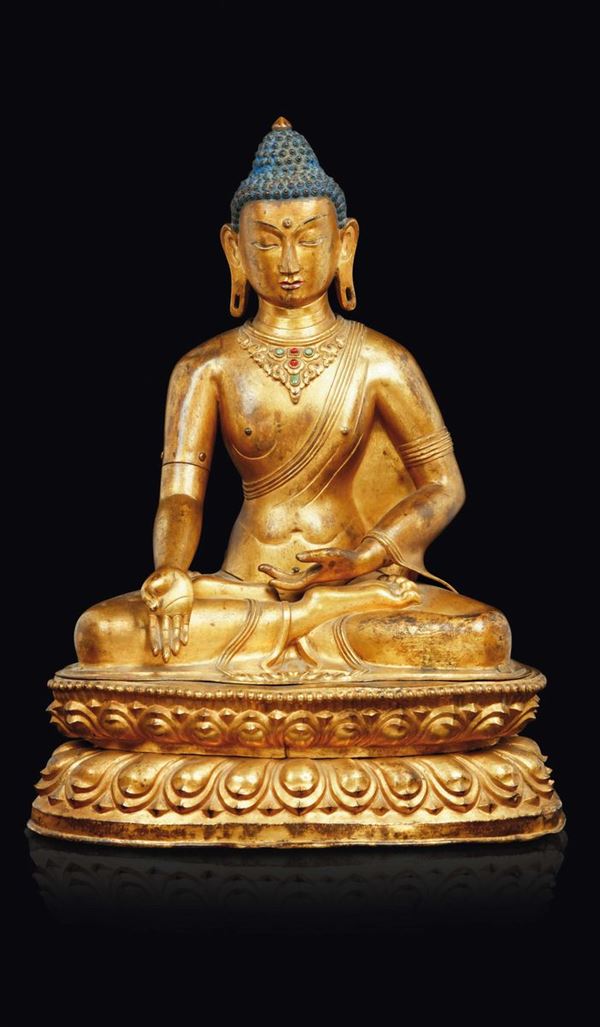 A gilt copper repoussé figure of Buddha seated on a double lotus flower with semi-precious stones inlays and inscription on the back, Tibet, 18th century