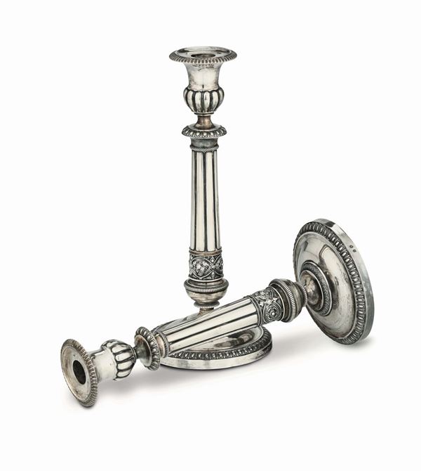 A pair of candlesticks in embossed and chiselled silver, Piacenza 19th century. Guarantee marks in use from 1821 to 1872 (letter E and lily)