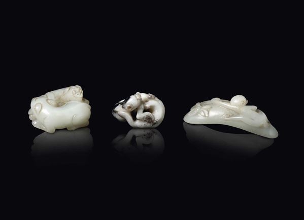 Three white and russet jade groups of dogs and a monkey on a leaf, China, 20th century