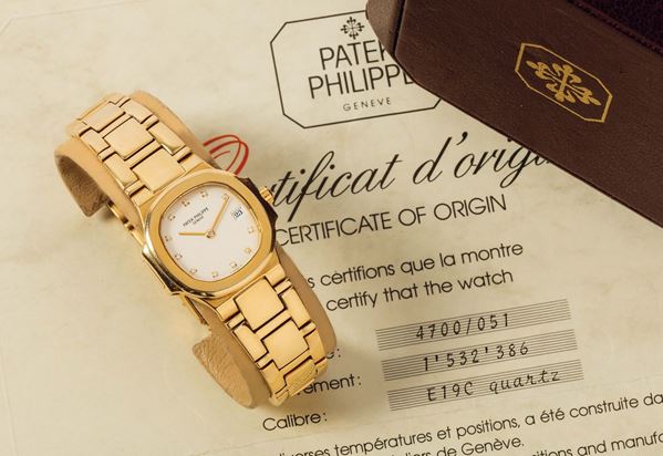 PATEK PHILIPPE, Geneve, Nautilus, REF. 4700, Yellow Gold and Diamond. Fine, water-resistant, 18K yellow gold lady's quartz wristwatch with diamonds, date and an integrated Patek Philippe 18K yellow gold bracelet with an 18K white gold clasp. Accompanied by the original box and Certificate