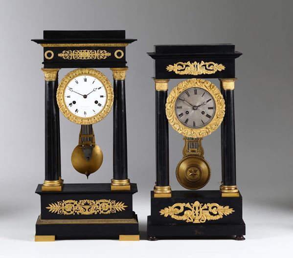 Due orologi con cassa in legno ebanizzato e applicazioni in bronzo dorato, Francia XIX secolo