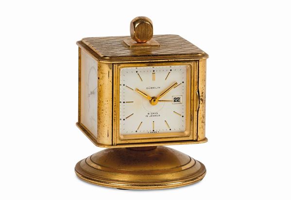 GUBELIN, No. 5044, orologio a forma di cubo, girevole in ottone dorato,  8 giorni di carica  con datario, igrometro, barometro e termometro. Realizzato nel 1960 circa