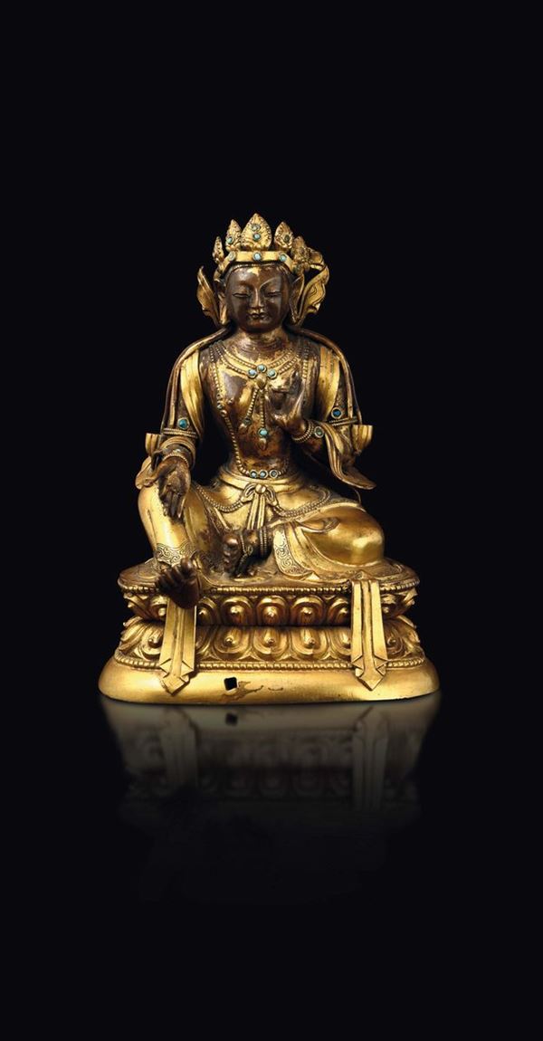 A gilt copper repoussé figure of Amitayus with turquoise inlays seated on a double lotus flower, China, Qing Dynasty, 18th century