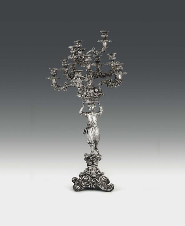 Grande candelabro in argento sbalzato, cesellato e fuso, manifattura napoletana, XIX secolo.