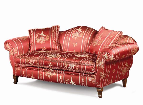 An upholstered sofa with a shaped backrest and curled walnut feet, 20th century