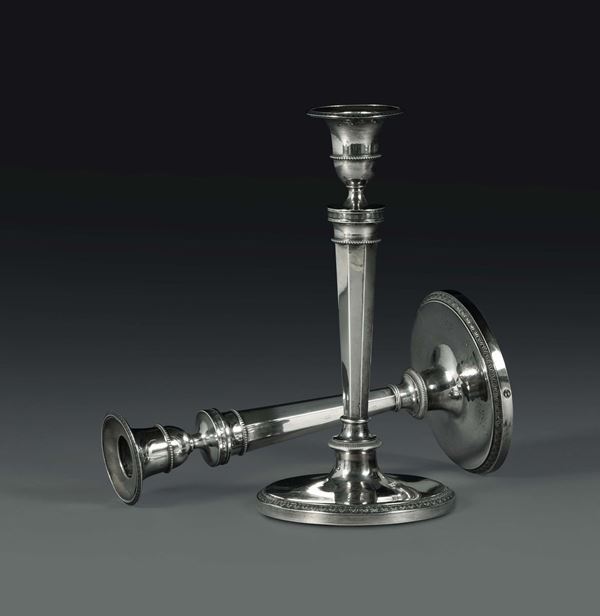 A pair of candlesticks in molten, embossed and chiselled silver, Italian manufacture from the 19th century, unidentified silversmith's mark.