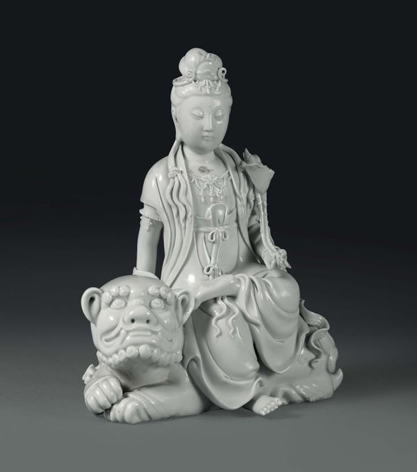A Guanyin sitting on a Pho dog in Blanc de Chine porcelain, China, Qing dynasty, 19th century
