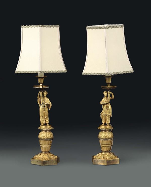 A pair of gilt bronze lamps with figures holding a cornucopia, Charles X period, France 19th century
