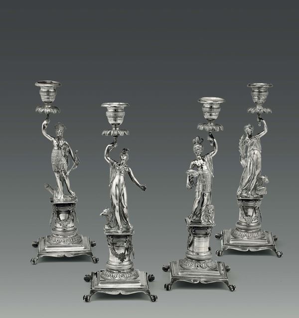 Gruppo di quattro candelieri raffiguranti i quattro continenti in argento fuso, sbalzato e cesellato,  [..]