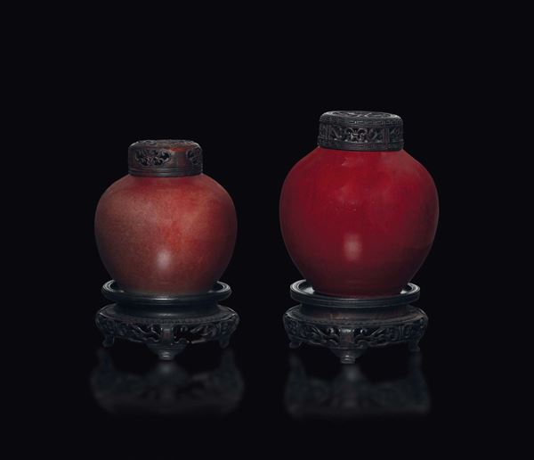 Due potiches con copercio in legno in porcellana monocroma sangue di bue, Cina, Dinastia Qing, XIX secolo