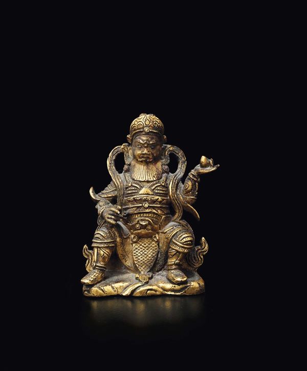 Piccola figura di Guandi seduto in bronzo dorato con pesca in mano, Cina, Dinastia Ming, XVII secolo