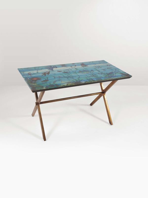 Tavolo basso con piano in legno decorato con decalcomania e struttura in metallo.